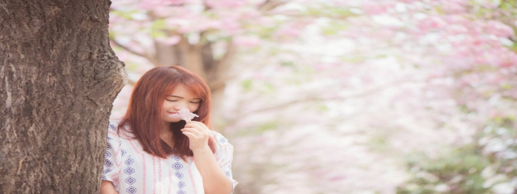 girl sniffing flower